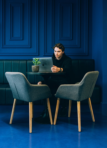 Persona sentada viendo un portátil